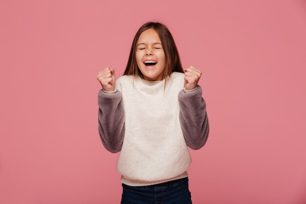 Ragazza felice del brunette che fa gesto del vincitore isolato