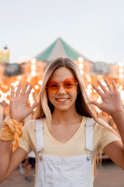 Ragazza felice del colpo medio al luna park