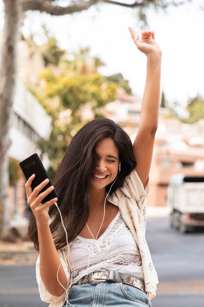 Ragazza felice del colpo medio che ascolta la musica