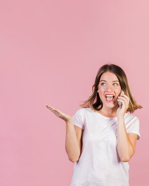 Ragazza felice del colpo medio che parla sopra il telefono