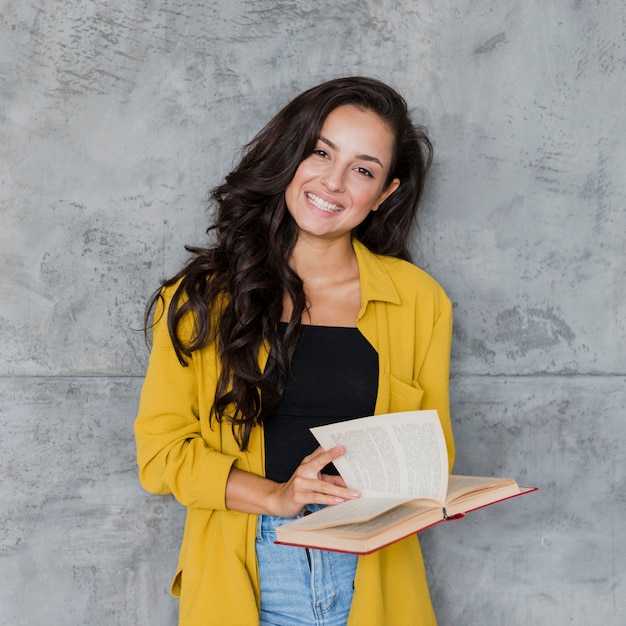 Ragazza felice del colpo medio con il fondo del cemento