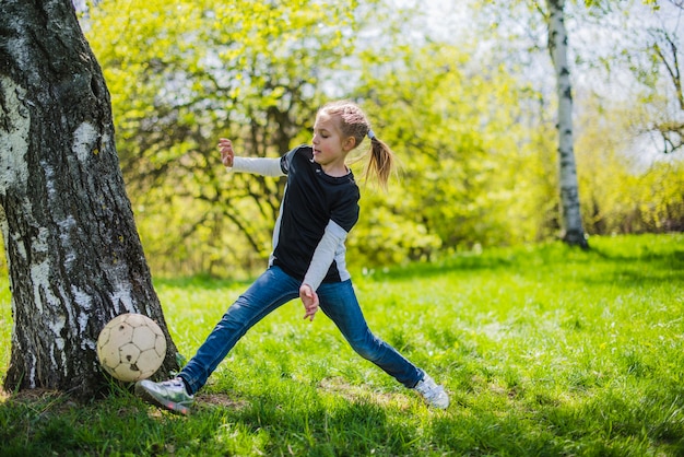 Ragazza felice giocando a calcio