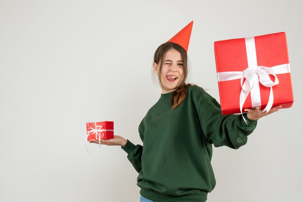 ragazza felice guardando il suo regalo di Natale che mostra la sua lingua su bianco