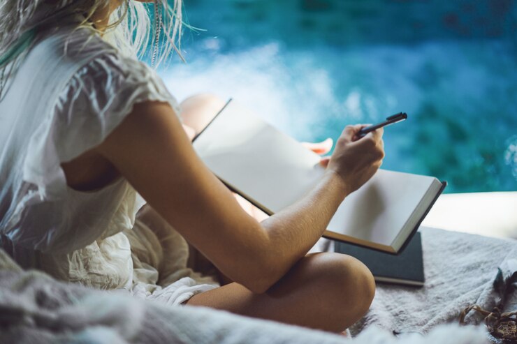 ragazza felice passa il tempo a casa in un interno accogliente, scrive e disegna in un quaderno.