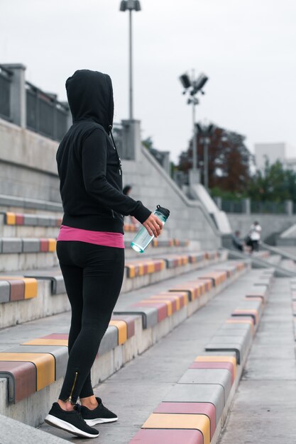 ragazza fitness con bottiglia d'acqua in mano