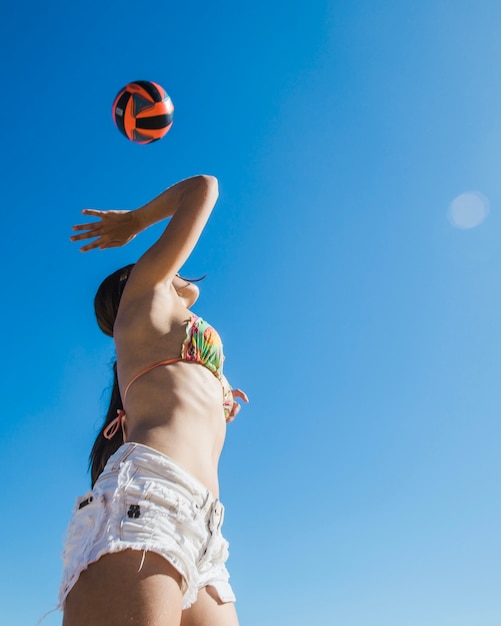 Ragazza giocare a pallavolo vista dal basso