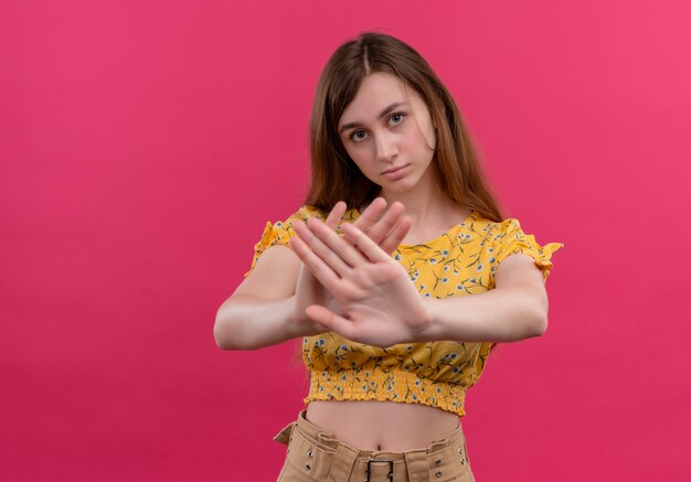 Ragazza giovane dispiaciuta che fa gesto di arresto sulla parete rosa isolata con lo spazio della copia