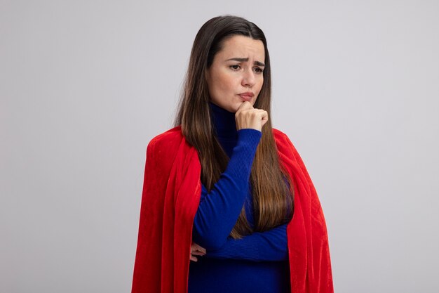 ragazza giovane supereroe pensieroso guardando il mento afferrato lato isolato su bianco