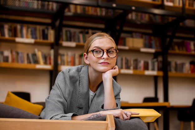 Ragazza graziosa che propone alla biblioteca