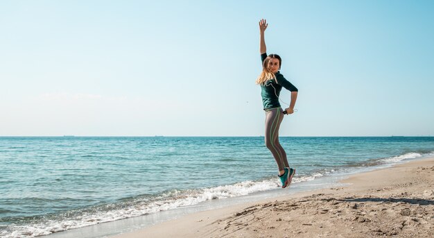 Ragazza in abbigliamento sportivo fitness ascoltando il mare