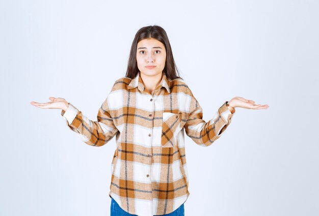 ragazza in abiti casual sentirsi sbalordita sul muro bianco.