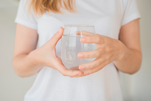 Ragazza in buona salute che tiene bicchiere d&#39;acqua