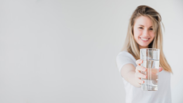 Ragazza in buona salute che tiene bicchiere d&#39;acqua