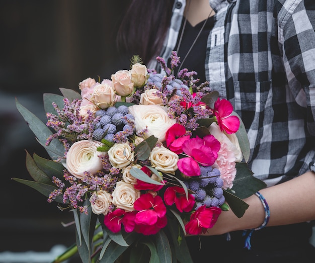 Ragazza in camicetta a quadri con bouquet di fiori in mano