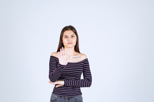 Ragazza in camicia a righe che ferma un pericolo.