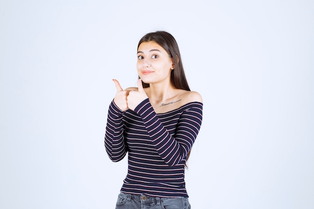 Ragazza in camicia a righe facendo segno di godimento.