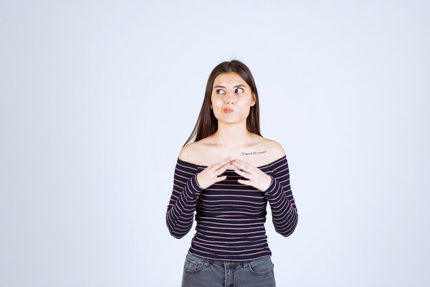 Ragazza in camicia a righe pensando e analizzando.