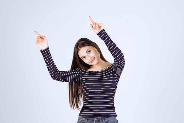 Ragazza in camicia a righe rivolta verso l'alto e mostrando emozioni.