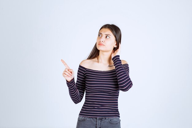 Ragazza in camicia a righe rivolta verso l'alto e mostrando emozioni.