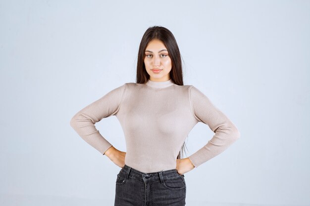 Ragazza in camicia grigia che dà pose positive e accattivanti.