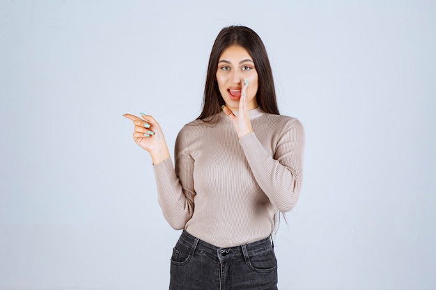 Ragazza in camicia grigia che fa pettegolezzo.