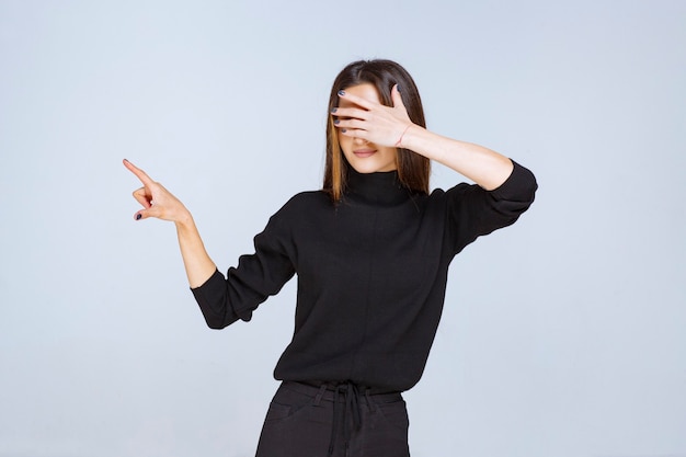 Ragazza in camicia nera che mostra il lato sinistro. Foto di alta qualità