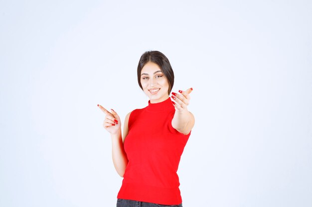 Ragazza in camicia rossa che nota qualcuno davanti e lo saluta.