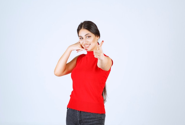 Ragazza in camicia rossa che nota qualcuno davanti e lo saluta.