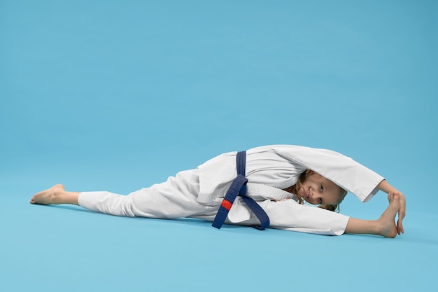 Ragazza in kimono che fa spago, raggiungendo il piede.