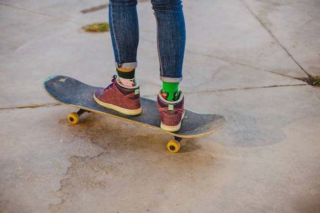 Ragazza in piedi sullo skateboard esterno