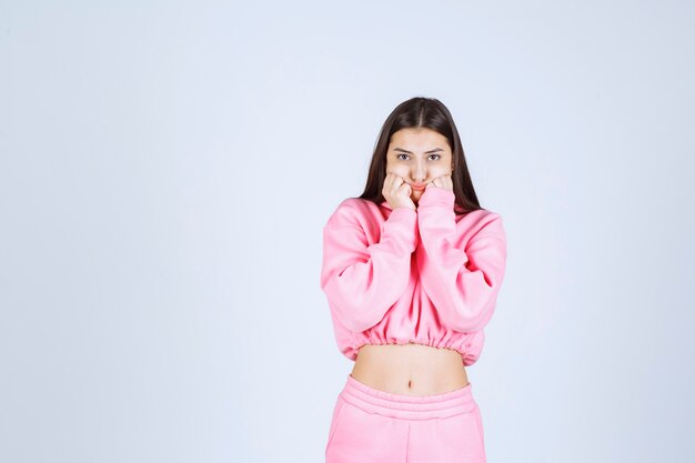 Ragazza in pigiama rosa sorpresa e scioccata