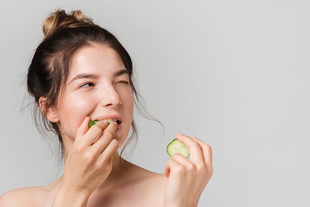 Ragazza in posa con fette di cetriolo