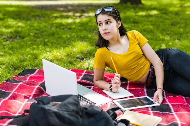 Ragazza in posa con tecnologia, matita e notebook