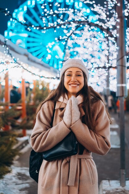 Ragazza in posa sullo sfondo di alberi decorati