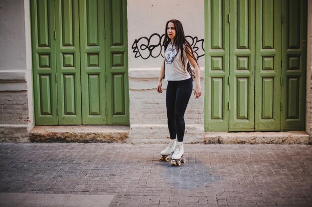 Ragazza in rollerskates in piedi sulla strada