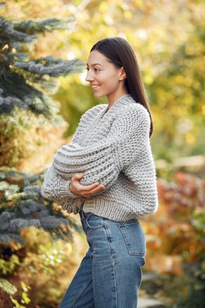 Ragazza in un maglione grigio che posa all'aperto