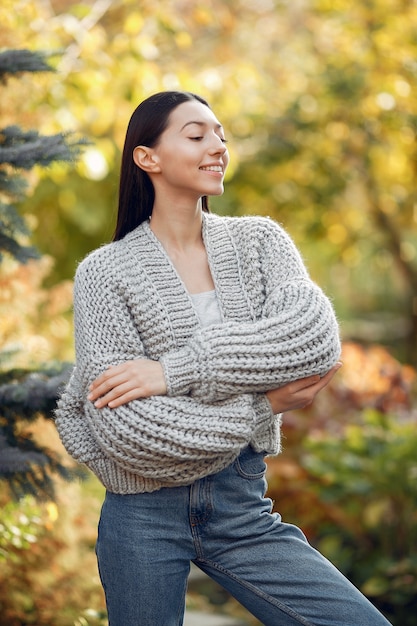 Ragazza in un maglione grigio che posa all'aperto