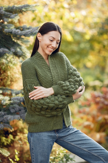 Ragazza in un maglione verde che posa all'aperto