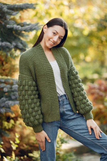 Ragazza in un maglione verde che posa all'aperto