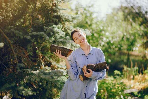 Ragazza in una camicia blu che sta sugli alberi