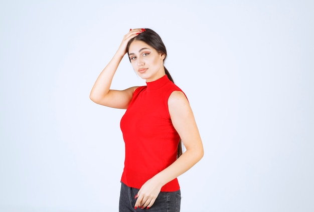 Ragazza in una camicia rossa che dà pose positive e seducenti.