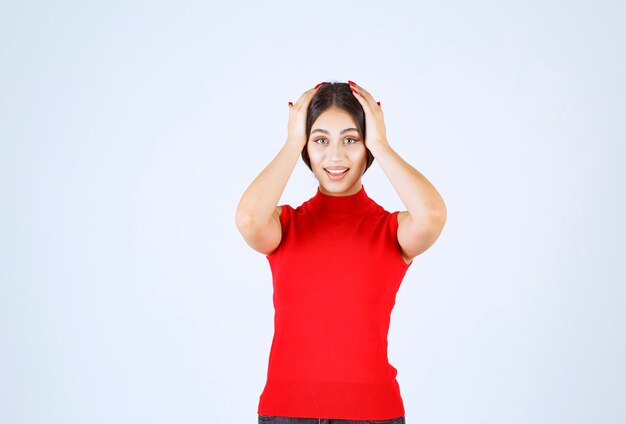 Ragazza in una camicia rossa che dà pose positive e seducenti.