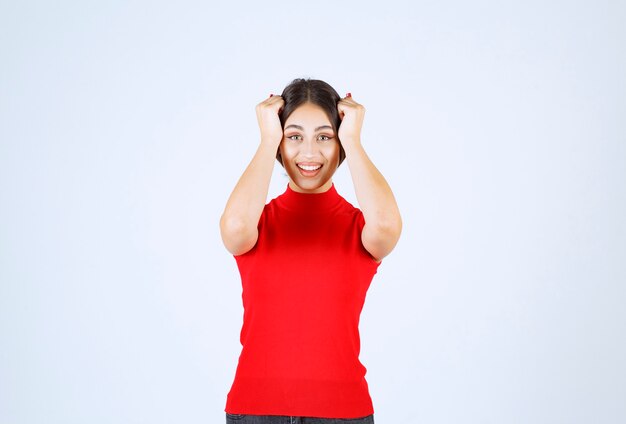 Ragazza in una camicia rossa che dà pose positive e seducenti.