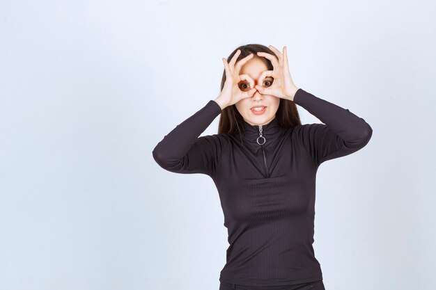 Ragazza in vestiti neri che mostrano il segno di godimento del cerchio.