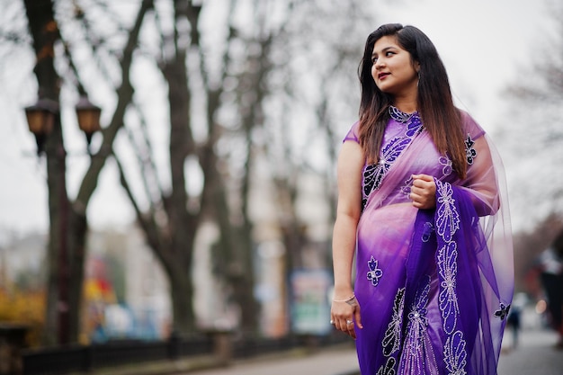 Ragazza indù indiana al tradizionale saree viola poste in strada