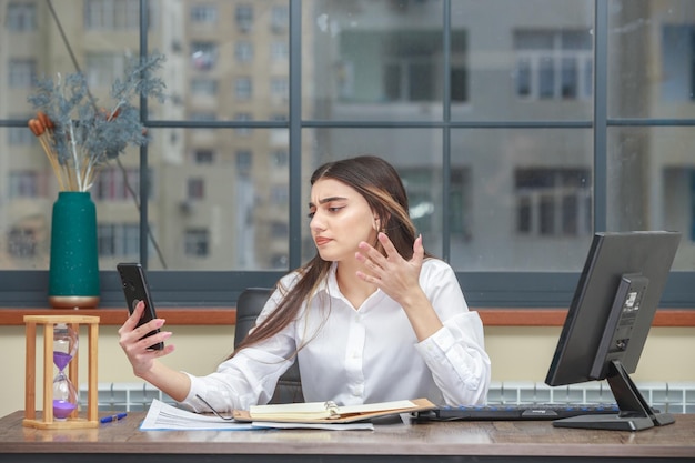 Ragazza infastidita che tiene il telefono e lo guarda