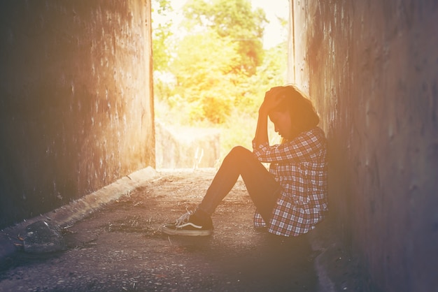 Ragazza infelice si siede sul pavimento