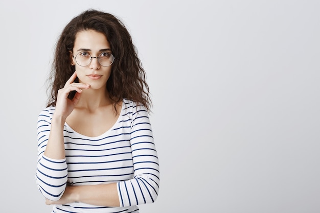 Ragazza intelligente con gli occhiali che sembra determinata