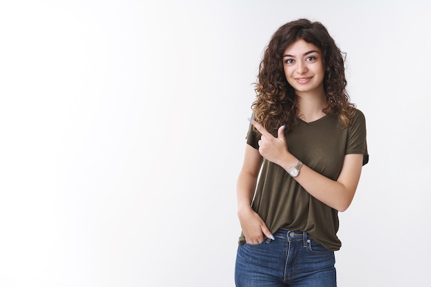 Ragazza invitante afferrare morso rivolto a sinistra caffè locale sorridente amichevole chiedendo amico fuori in piedi positivo fortunato sfondo bianco tenere la tasca della mano casualmente parlando conversazione informale