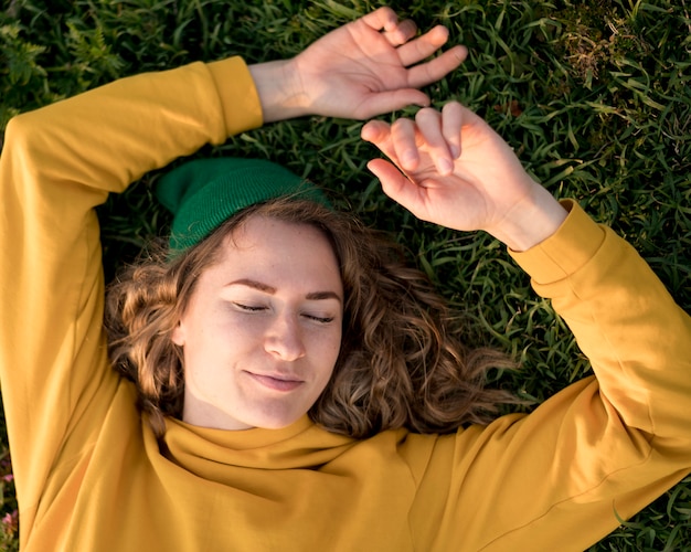 Ragazza libera di vista superiore che resta sull'erba